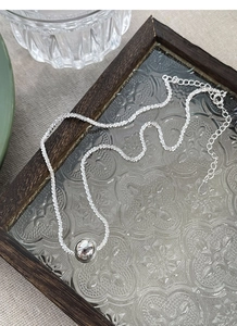 Detail of S925 sterling silver beaded necklace with polished sphere on textured chain