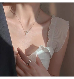 Close-up of S925 sterling silver star necklace and hollow ring worn by elegant model