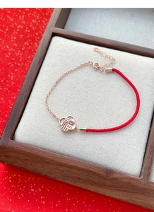 Détail du bracelet en argent S925, cordon rouge, pendentif trèfle et caractère Fu