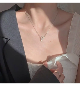 Detail of elegant gold planet and star necklace worn by a model in soft shadows
