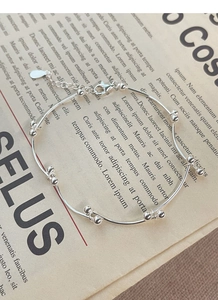 Macro shot of polished S925 sterling silver bead bracelet with adjustable chain