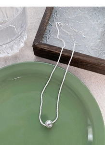 Macro detail of S925 sterling silver ball pendant necklace with sparkling link chain