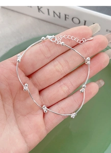 Detailed macro shot of the S925 sterling silver stamp on the minimalist beaded bracelet