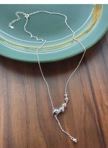 Detail der S925 Sterling Silber Y-Halskette mit polierten Perlen auf Keramikteller