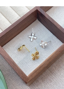 Detailed macro view of S925 sterling silver gardenia stud earrings in gold and matte silver