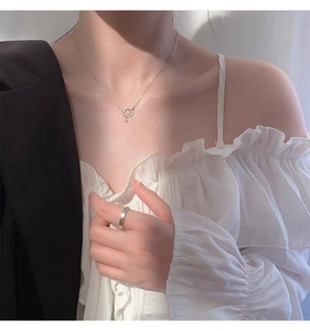 Detail of S925 silver planet necklace and minimalist ring on model for elegant look