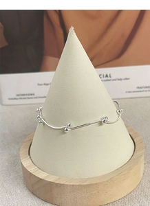 Detailed view of S925 sterling silver bean knot bracelet on a jewelry display stand