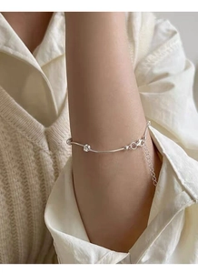 Detail of S925 sterling silver bean knot bracelet on wrist with minimalist design
