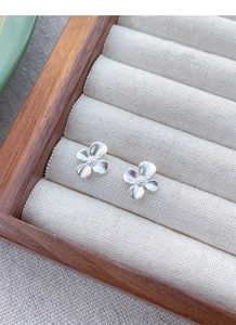 Detailed macro view of S925 sterling silver gardenia stud earrings with matte brushed finish