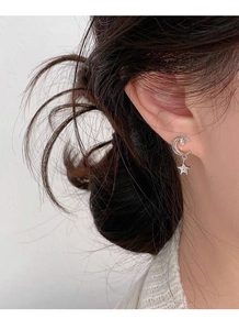 Close-up of S925 sterling silver star and moon earrings with sparkling zircon on ear