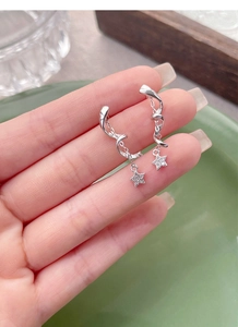 Detail of S925 silver spiral star earrings with zircon inlay held by hand