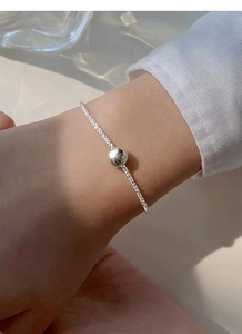 Close-up of a minimalist S925 sterling silver bead bracelet worn on a woman wrist