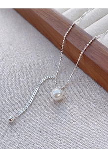 Detail view of S925 silver pearl necklace featuring elegant round beads and tassel design