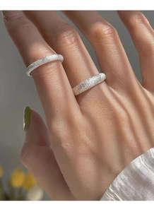 Detail of silver S925 rings with stardust matte finish on fingers for a sparkling texture
