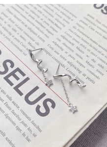 Macro detail of S925 sterling silver rotating star earrings with elegant tassel design