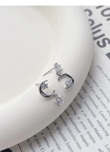 Detailed close-up of S925 sterling silver moon and star earrings with zircon stones