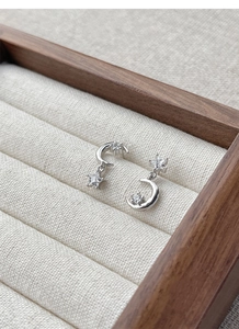 Macro view of asymmetric S925 silver star and moon stud earrings set with zircon stones