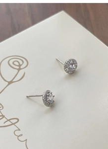 Détail macro des boucles d'oreilles halo en argent 925 avec des pierres de zircone