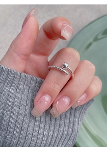 Detailed close-up of a silver adjustable bead ring on a hand with soft knit background