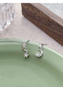 Macro shot of S925 sterling silver star and moon earrings with sparkling zircon inlay