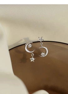 Detail view of S925 sterling silver moon and star earrings with cubic zirconia stones