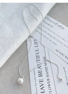 Macro detail showing S925 sterling silver stamp on minimalist pearl pendant chain necklace