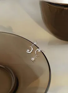 Detailed macro view of S925 sterling silver star and moon earrings with cubic zirconia