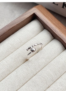 Detail shot of a S925 sterling silver minimalist beaded open ring on a wooden jewelry tray