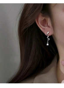 Silver star drop earrings with spiral design and tassel chain worn by model