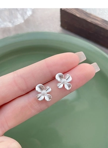 Detail view of S925 sterling silver gardenia stud earrings with elegant matte floral finish