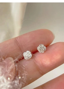Macro shot of S925 sterling silver camellia stud earrings with detailed petal texture