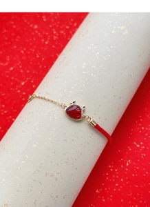 Détail du bracelet en argent S925 avec cordon rouge, agate et finitions dorées