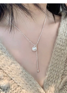 Detail of S925 sterling silver Y-shaped pearl necklace with tassel chain on model