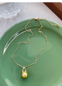 Macro detail of gold pearl pendant with micro-inlaid zircon on S925 sterling silver chain