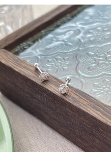 Detailed macro view of S925 sterling silver camellia stud earrings with secure screw backs