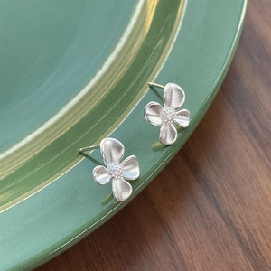 S925 sterling silver gardenia flower stud earrings with matte finish on green plate