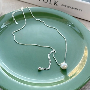 Elegant S925 sterling silver beaded necklace with white pearl pendant on green plate