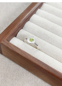 Gros plan sur bague en argent S925 avec zircon vert et détails de texture solaire