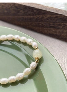 Macro detail of S925 silver freshwater pearl bracelet with green jade and gold spacers