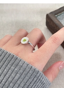 Détail d'une bague en argent S925 avec zircon vert et plaque en métal ronde texturée