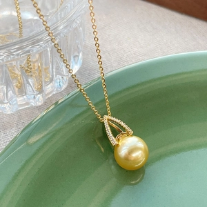 Elegant S925 silver gold pearl necklace with crystal pendant on a ceramic dish