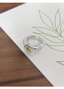 Détail macro de bague en argent S925 avec zircon vert et gravure texture soleil