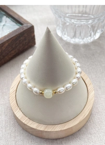 Detail of S925 silver freshwater pearl bracelet with green Hetian jade and gold spacers