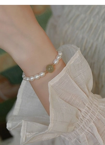 Detail view of S925 silver bracelet with freshwater pearls and green jade on a wrist