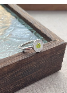 Détail macro de la bague en argent S925 avec zircon vert et texture gravée radiale