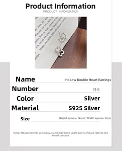 Detail view showing silver S925 heart earrings size specifications on a wooden desk