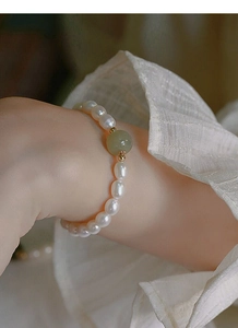 Detail of S925 silver bracelet with freshwater pearls and a green jade centerpiece