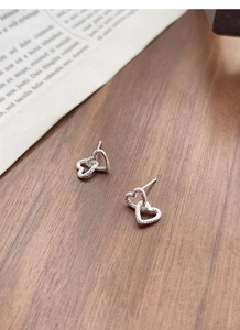 Close-up of S925 sterling silver interlocking hollow hearts with textured surface