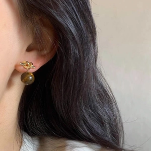 Elegant S925 silver knot earrings with brown tiger eye stones worn by a model