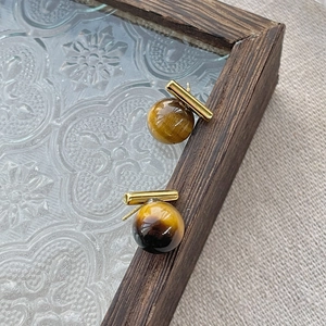 S925 silver tiger eye stud earrings with gold T-bar detail on vintage wood tray